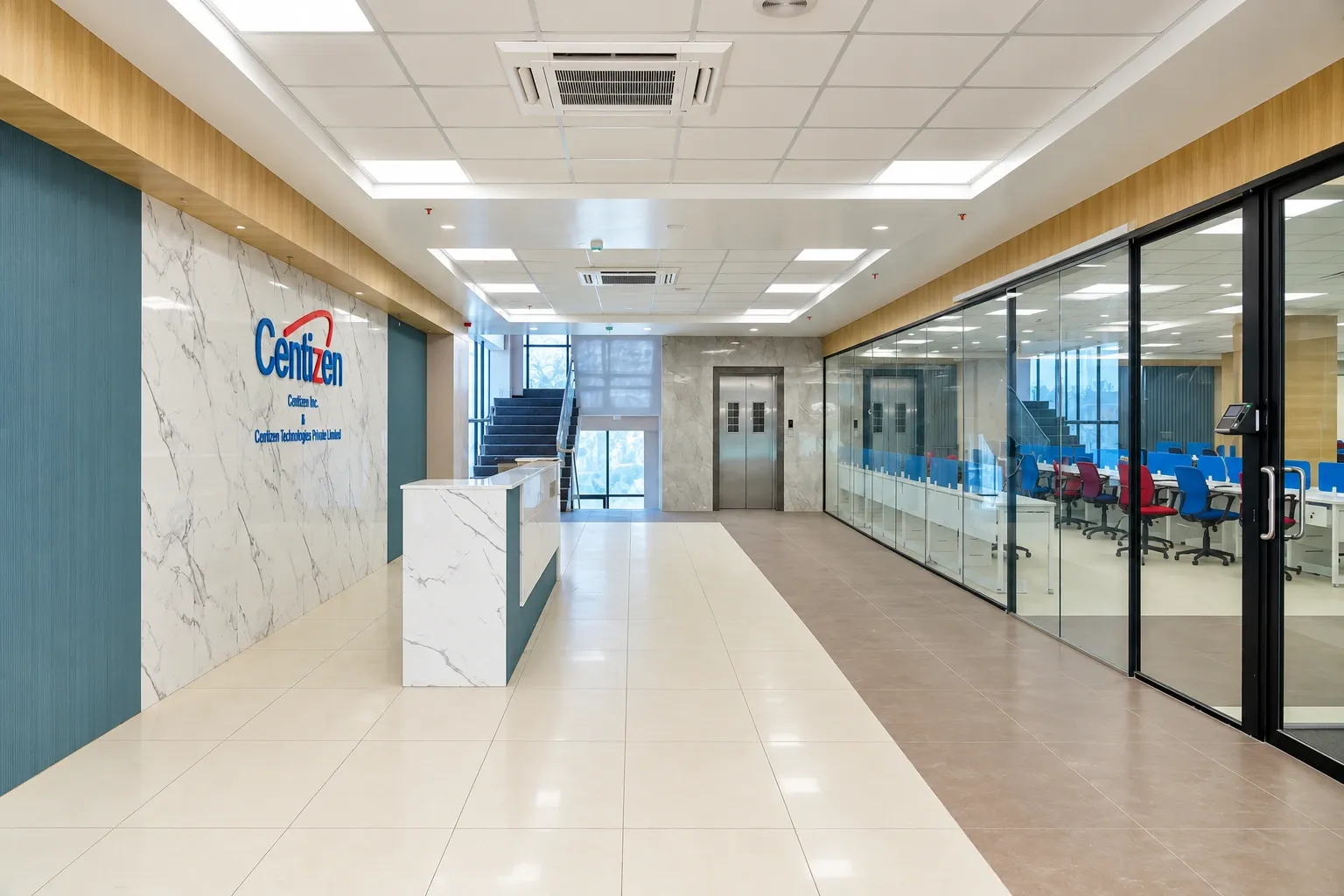 Reception at Centizen, with the company logo on a marble wall and a glass wall that opens onto the work floor